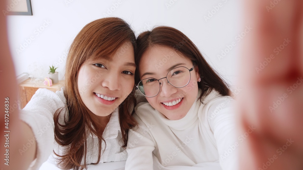Homosexual Asian women lesbian couple lying on the bed looking at the camera. LGBT friendship concept Homosexual Asian women lesbian couple lying on the bed looking at the camera. LGBT friendship concept