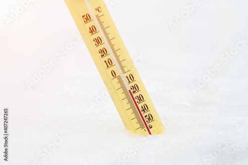 Wintertime. Thermometer in the snow shows very low temperatures. Fifteen degrees under zero celsius. Concept of weather forecast.