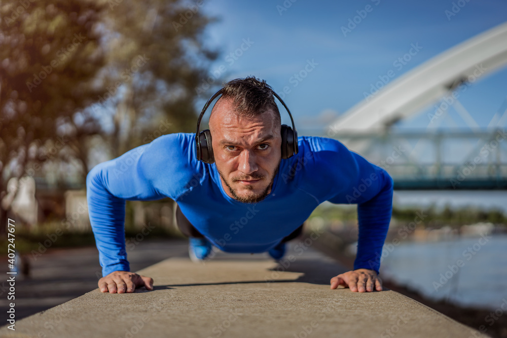 Young handsome man training hard. Man doing sports outside. Outdoors recreation, stretching and training fit body Young handsome man training hard. Man doing sports outside. Outdoors recreation, stretching and training fit body