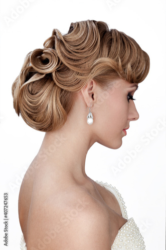 Profile portrait of a beautiful bride with fashion wedding hairstyle - on white background.