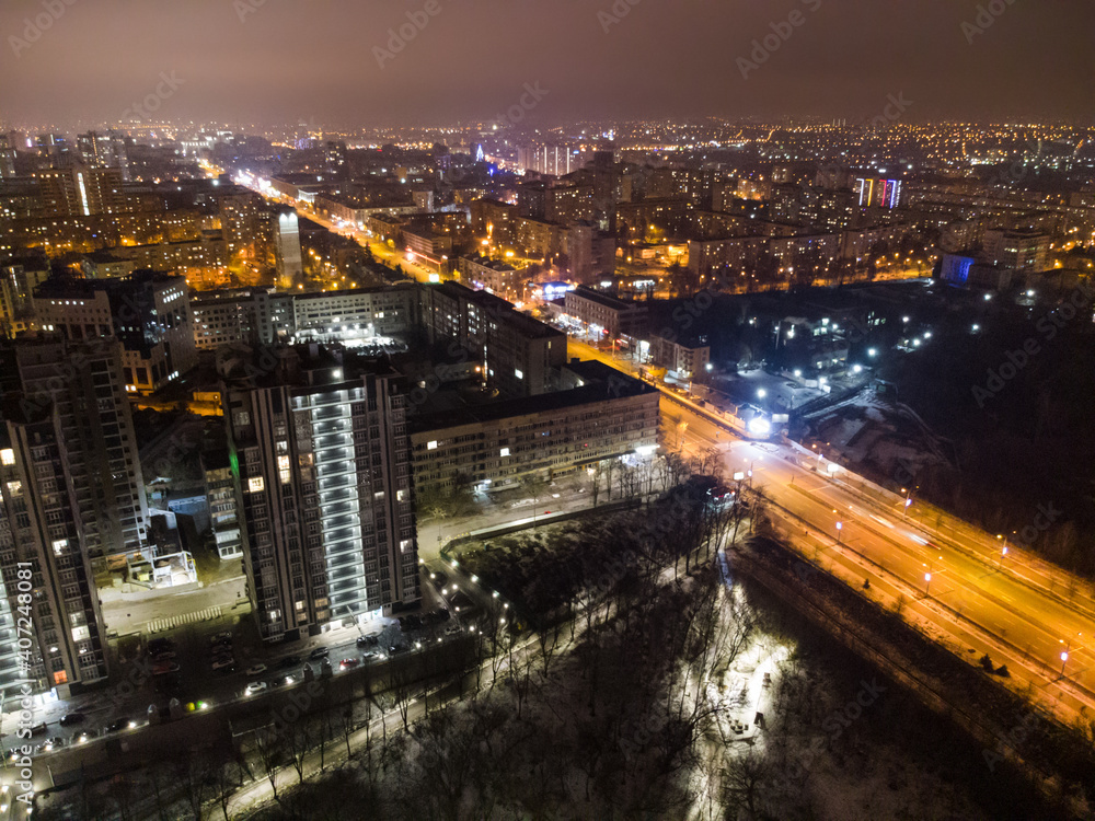 Kharkiv city center drone view on Nauky avenue. Botanical garden Sarzhyn Yar and multistorey modern high buildings at night. Aerial view on city lights streets