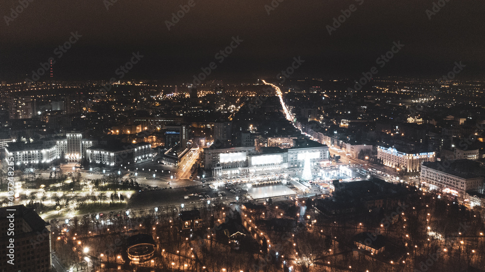 Freedom Svobody Square (Kharkiv) aerial view at night with New year holidays and Christmas tree decorations with colorful illumination in city center. Color graded
