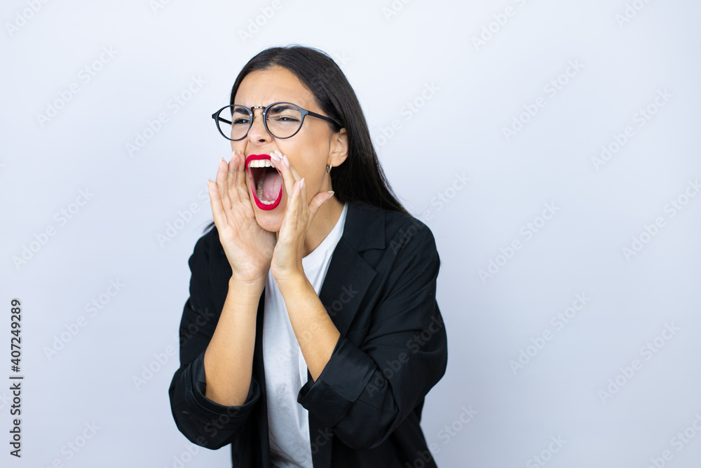 Beautiful business woman shouting and screaming loud to side with hands on mouth Beautiful business woman shouting and screaming loud to side with hands on mouth