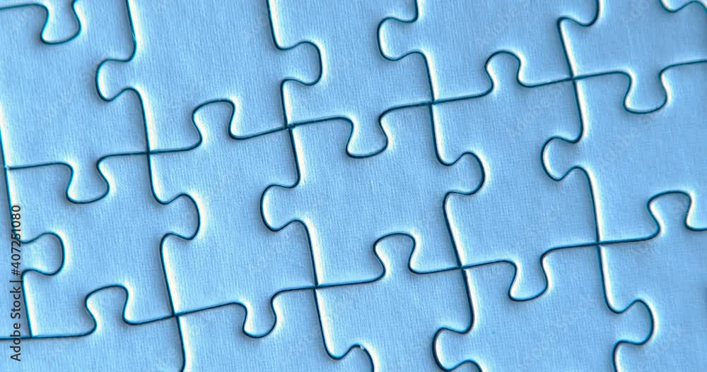 Gray puzzles stacked on blue background. Female hand is putting down one piece. Finishing, completion of work task. Successful achievement of goal. Decision, solution of problem, issue found. Gray puzzles stacked on blue background. Female hand is putting down one piece. Finishing, completion of work task. Successful achievement of goal. Decision, solution of problem, issue found.