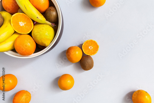 Ceramic fruit bowl with fresh, colorful healthy fruit, including kiwis, lemons, bananas and oranges fit and healthy nutritional advice personel training nutrition plan diet and weight loss organic