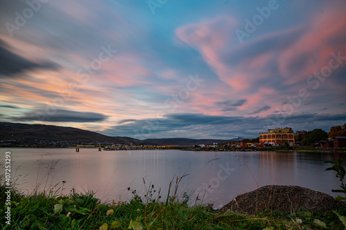 Shore of Troms   during sunset with mountains in the background