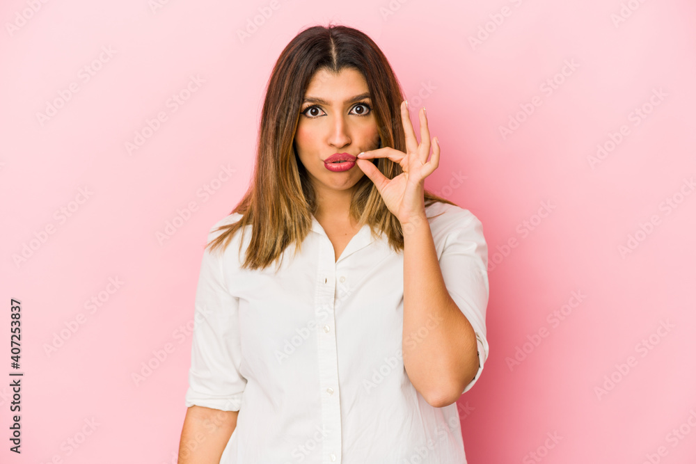 Young indian woman isolated on pink background with fingers on lips keeping a secret. Young indian woman isolated on pink background with fingers on lips keeping a secret.