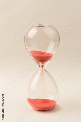 Crystal hourglass on champagne background as a concept of passing time for business term, urgency and outcome of time.