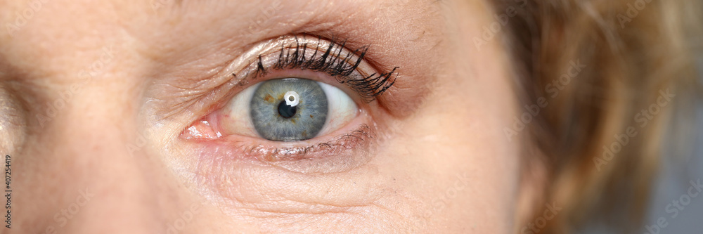 Blue eyes of an elderly woman. Healthy complexion and aging skin - obrazy, fototapety, plakaty 
