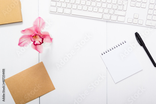 Wallpaper Mural place of work with pink orchid flower, keyboard, brown papers, checklist, black pen, top view Torontodigital.ca