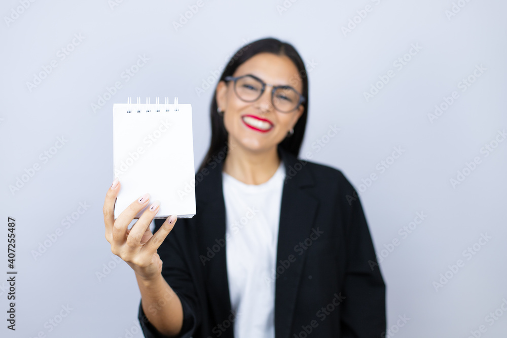 Beautiful business woman smiling showing blank notebook Beautiful business woman smiling showing blank notebook
