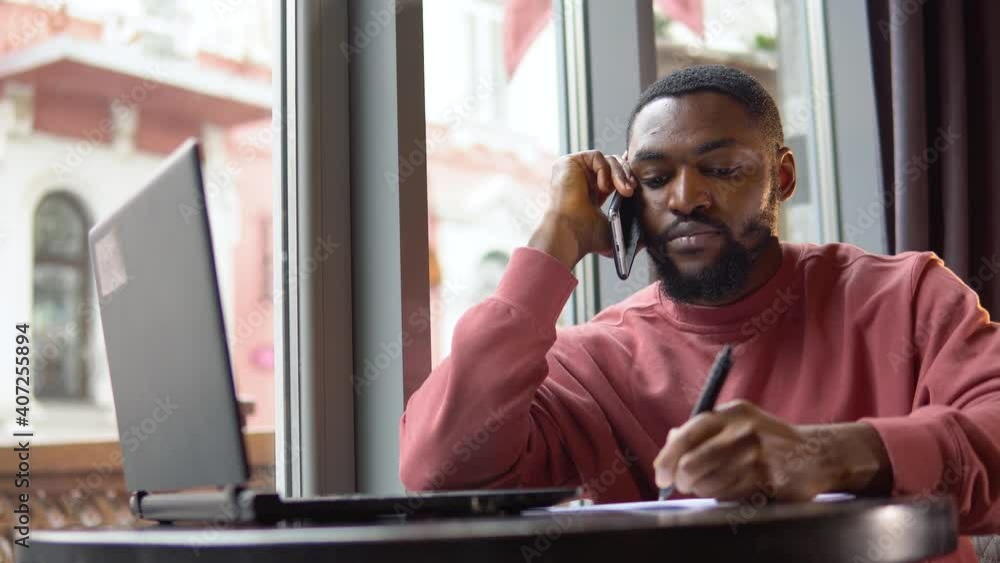 Man doing notes during his busines conversation