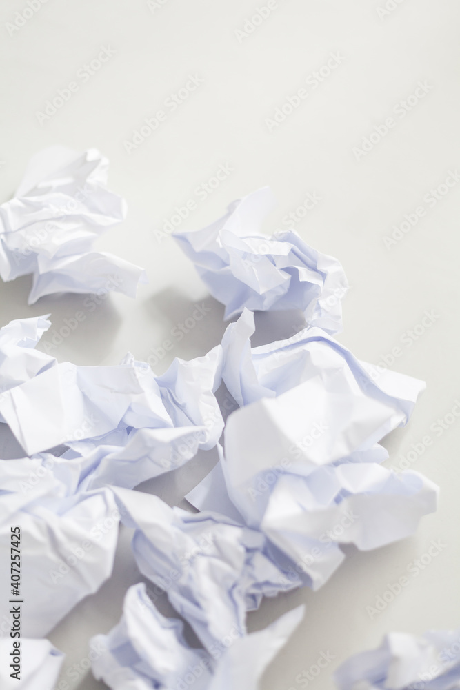 Crumpled sheets of paper against a white background. Tidying up chaos. Paperless office. Recyling documents. Overstrained. Business management. Resources. Economy