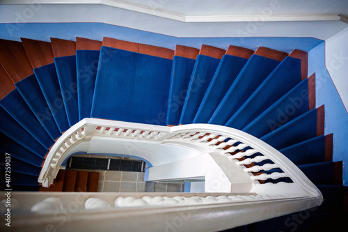 Beautiful snow-white stairs with beautiful railings and blue carpet.