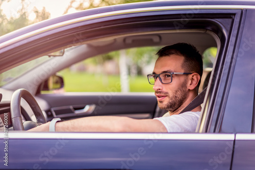 Driving with glasses. Young urban and handsome man with glasses in car driving  © Vladimir Borovic