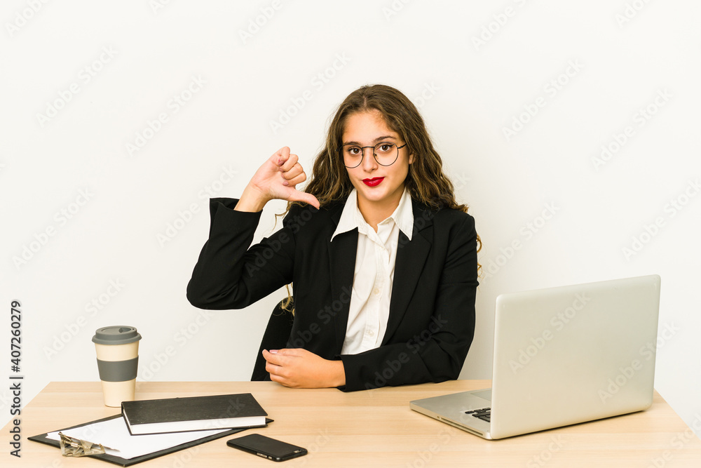 Young caucasian business woman working on her desktop isolated showing a dislike gesture, thumbs down. Disagreement concept. Young caucasian business woman working on her desktop isolated showing a dislike gesture, thumbs down. Disagreement concept.