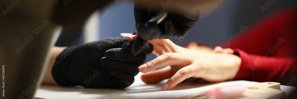 The manicurist processes the cuticles in the salon or at home during quarantine. Standard set for creating manicure