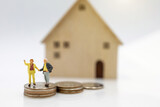 Miniature people: Elderly person standing on coins stack with home, Retirement planning concept.