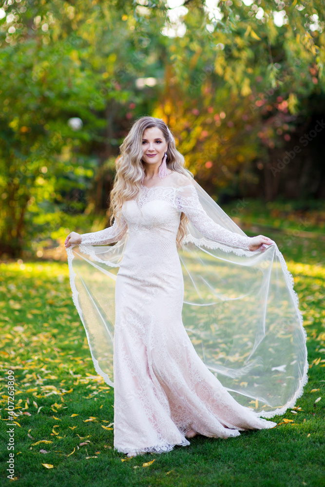 Blonde bride in a wedding dress straightened the veil