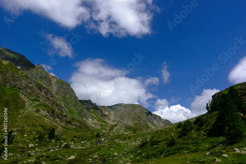 green mountains with soft white clouds on the deep blue sky