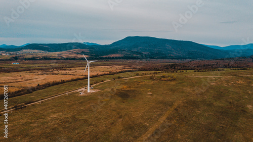Fototapeta Naklejka Na Ścianę i Meble -  View of a wind turbine in the mountains in the background, Alternative energy, Ukrainian windmill in a field in the Carpathian region.