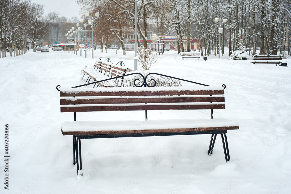 Bench covered with snow in the park
