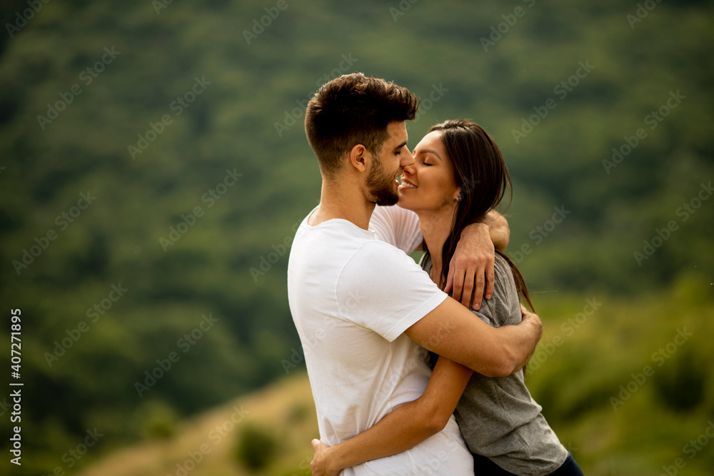 Happy young couple in love at the grass field