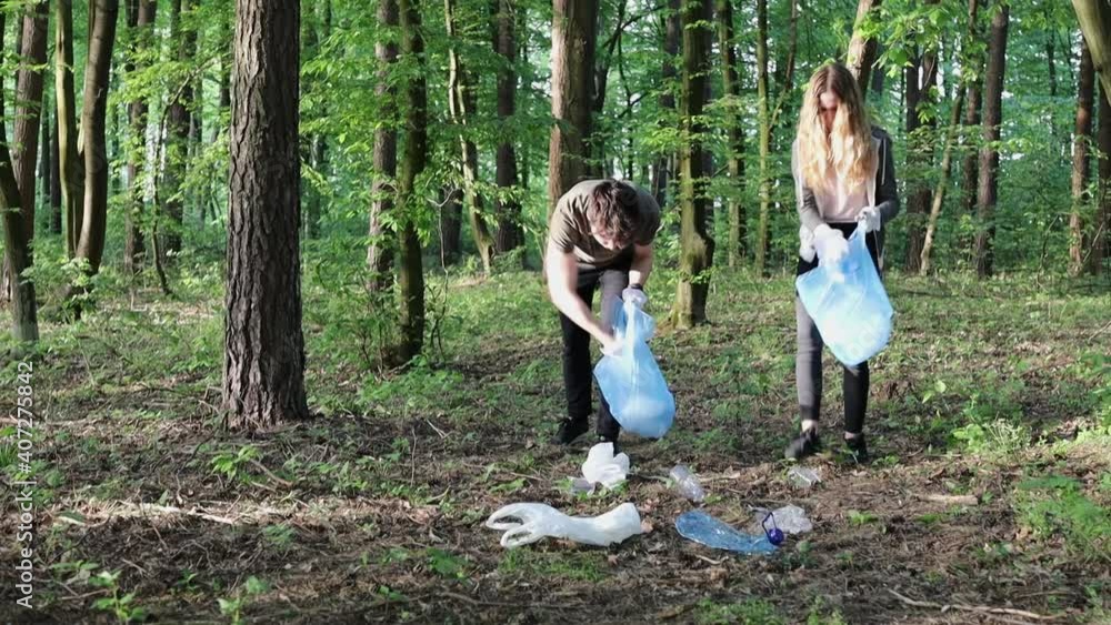 Volunteers cleaning up a forest. Volunteers picking plastic waste to bags. Concept of plastic pollution and too many plastic waste Volunteers cleaning up a forest. Volunteers picking plastic waste to bags. Concept of plastic pollution and too many plastic waste