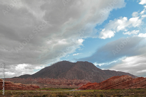 Desert landscape. View of the arid valley, sand, shrubs, red sandstone, rocky formations and mountains at sunset in Quebrada de las Conchas, Salta, Argentina.
