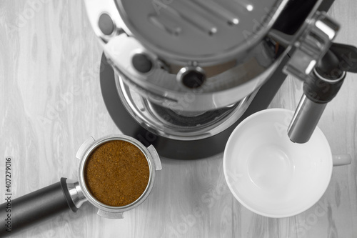 Top view of a portafilter of a coffee maker filled with ground coffee before making an espresso.