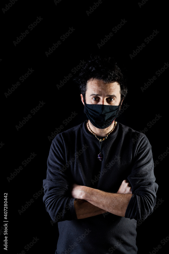 Obraz premium Corridor lighting setup portrait of an adult white man with rock hairstyle and beard looking attractive wearing mask and looking serious and responsible with negative space. 