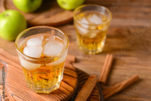 Tasty apple drink with cinnamon in glasses on wooden background © Pixel-Shot