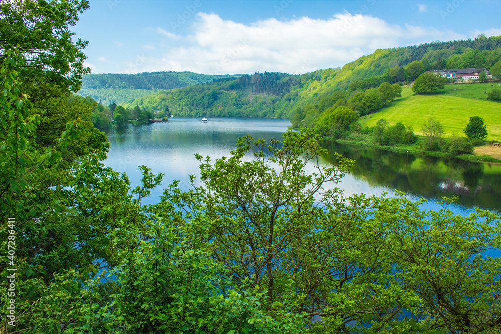 Rursee at Eifel National Park, Germany. Scenic view of lake Rursee and surrounded green hills in North Rhine-Westphalia Rursee at Eifel National Park, Germany. Scenic view of lake Rursee and surrounded green hills in North Rhine-Westphalia