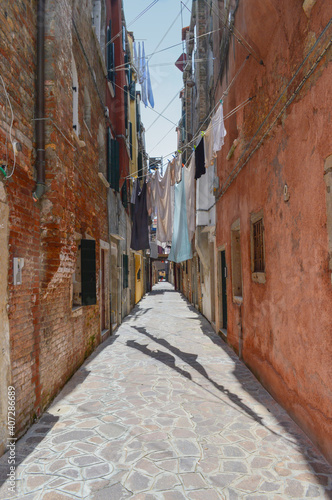 Schmale Gasse mit Wäscheleine in der Altstadt in Venedig, Italien