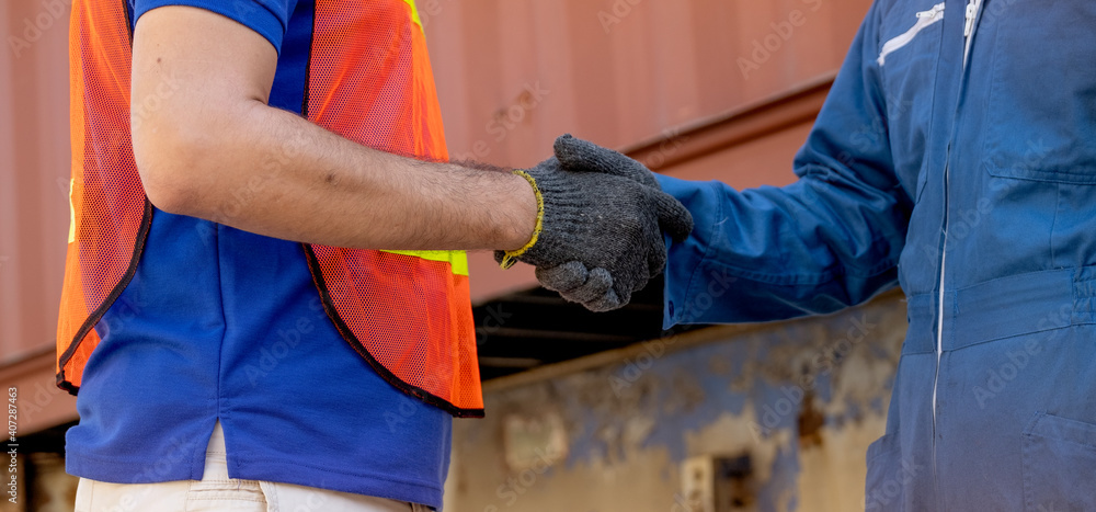 Close up hand shaking of cargo container worker or engineer in workplace area. Business Logistics import export shipping concept. Close up hand shaking of cargo container worker or engineer in workplace area. Business Logistics import export shipping concept.