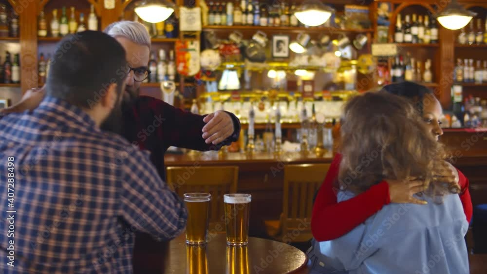 Diverse young friends meeting and hugging in beer pub Diverse young friends meeting and hugging in beer pub