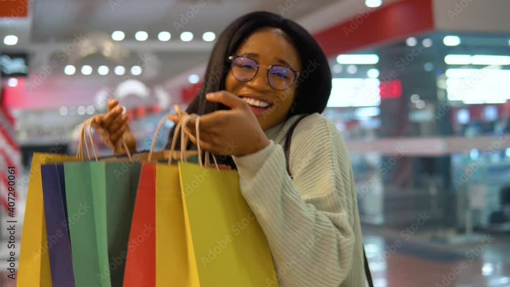 The girl enthusiastically looks in shopping bags The girl enthusiastically looks in shopping bags