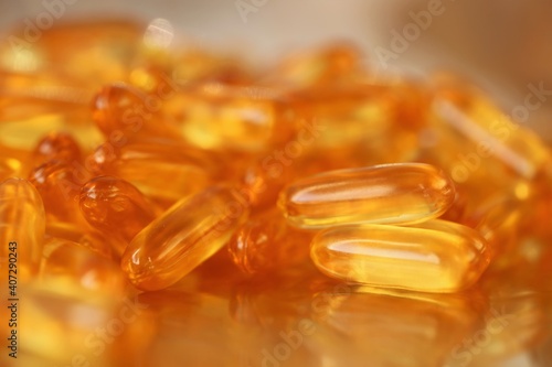 fish oil capsules close-up set on blurred gold background.Fish oil in gelatin capsules. Omega three.Supplements for a healthy diet. Healthy fats
