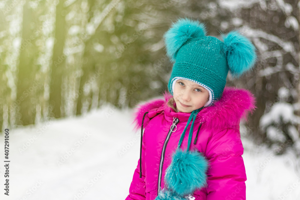 natural light. a girl in a red jacket and a green hat is surrounded by a lot of snow. He looks at us. Soft focus. natural light. a girl in a red jacket and a green hat is surrounded by a lot of snow. He looks at us. Soft focus.