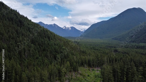 Forested valley with mountains surrounding and in the distance