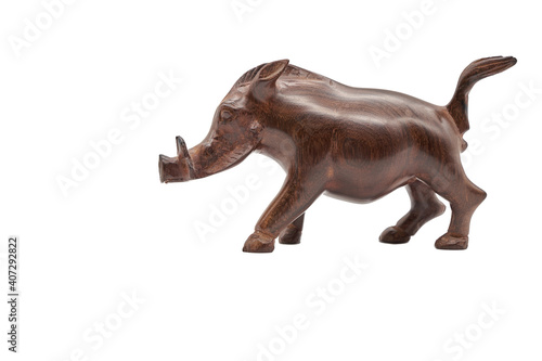 Brown warthog  Warzenschwein  made of wood  isolated on white background. The real pig  Suidae  has its home in Africa. Copy space. Side View.