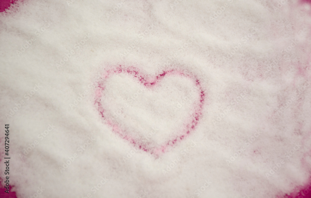 Heart shape drawn on white granulated sugar background. Sweet sugar heart with selective focus. Flat lay, Top view