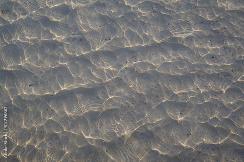 optics of water. Glare in the sand on the beach at the sea