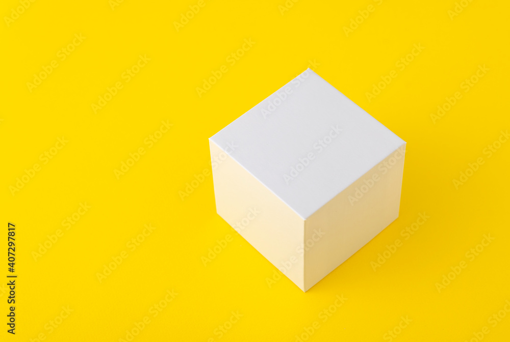 White cardboard box of square shape on yellow background. Copy space. Mock up. White cardboard box of square shape on yellow background. Copy space. Mock up.