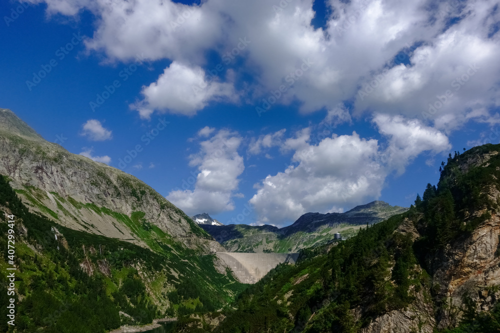dam wall in a mountain valley with beautiful sky
