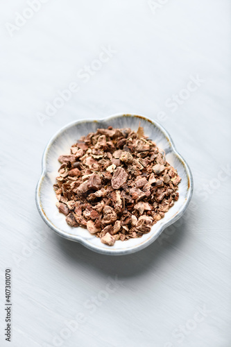 Dry root of Rhodiola rosea. Golden root, rose root. Healthy medical plant on wooden background. Close up. 