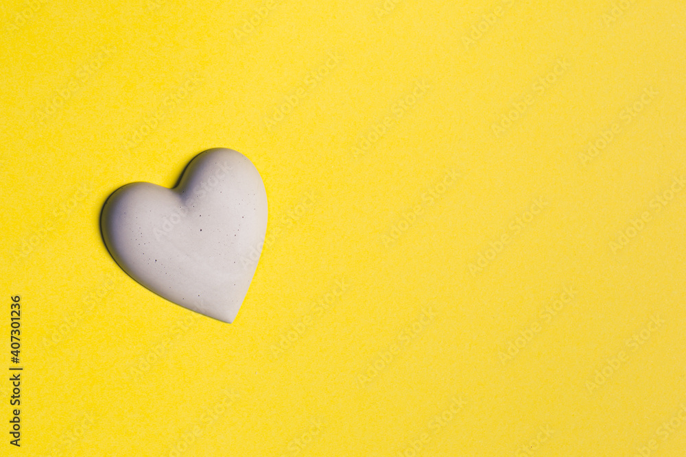 Concrete heart on yellow paper background Concrete heart on yellow paper background