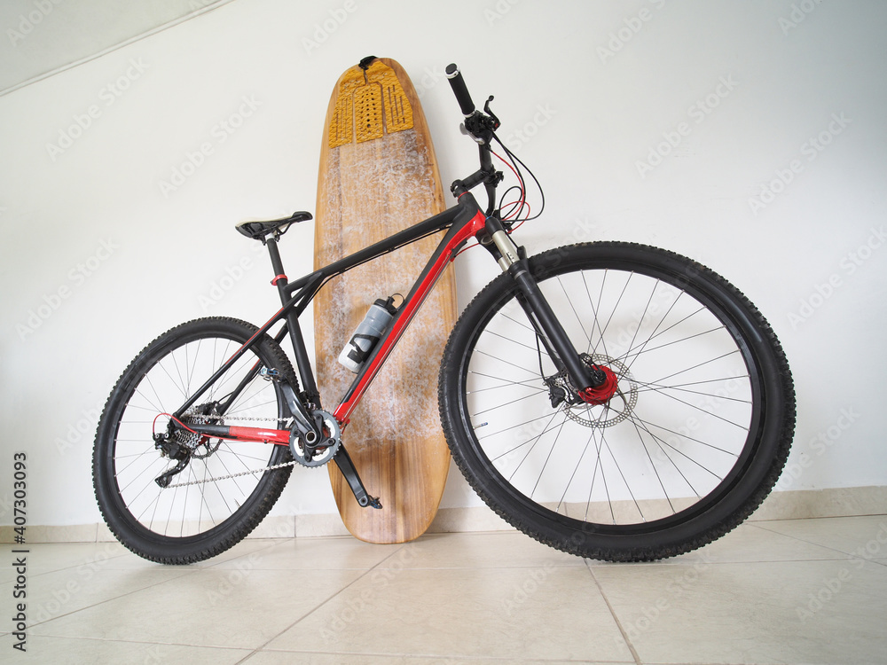 Obraz premium Bicycle with a surfboard at home. Sport concept.