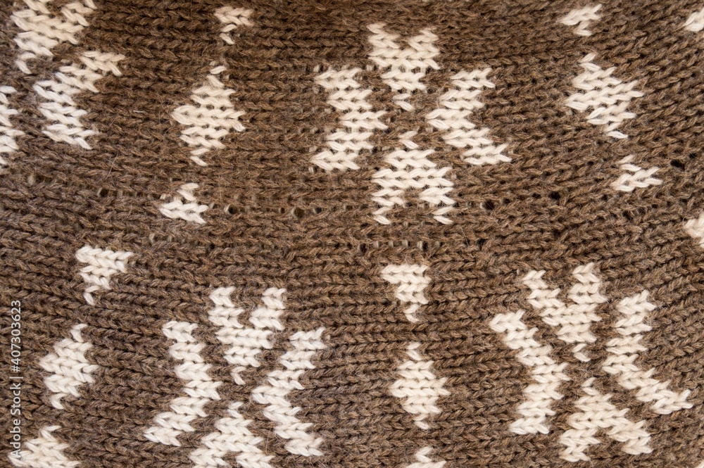 The texture of a woolen knitted fabric with a pattern. The texture of a woolen knitted fabric with a pattern.