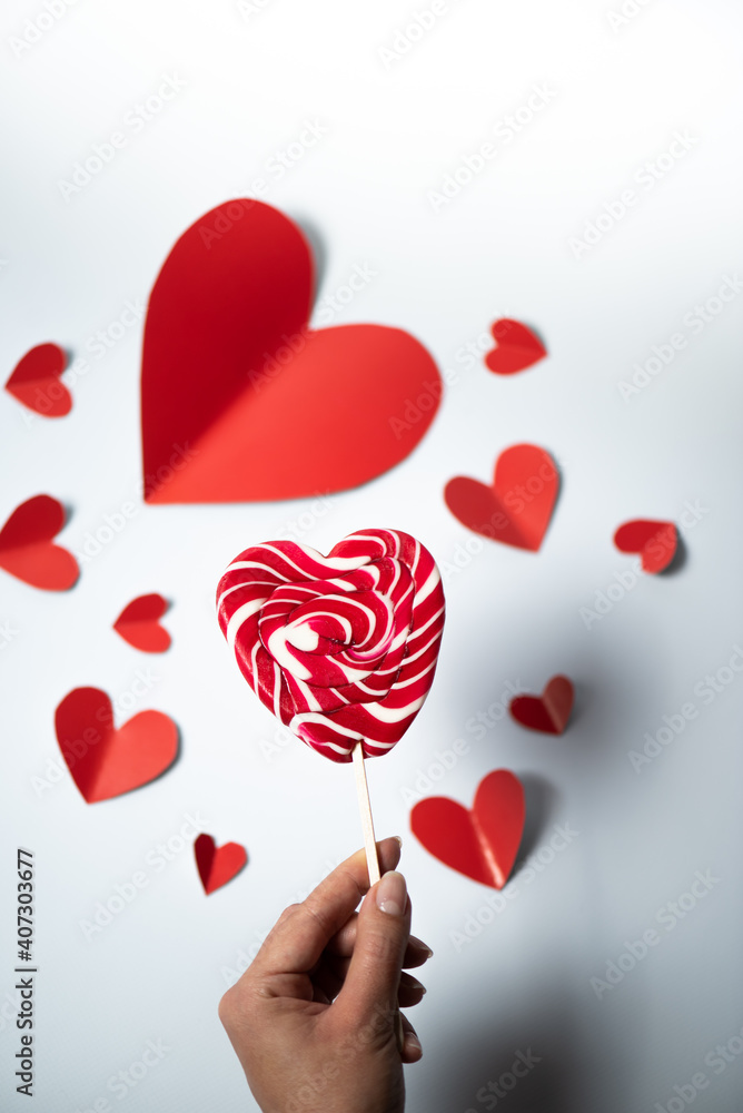 Valentine's Day background. red hearts and lollipop on white background. Valentines day concept. Flat lay, top view, copy space Valentine's Day background. red hearts and lollipop on white background. Valentines day concept. Flat lay, top view, copy space